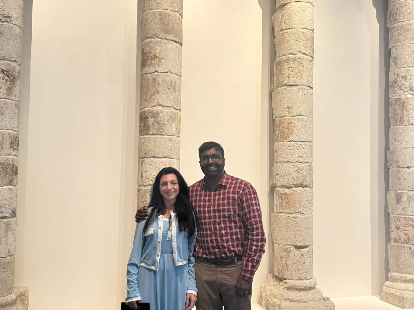Rusul and Ashir standing together between stone columns